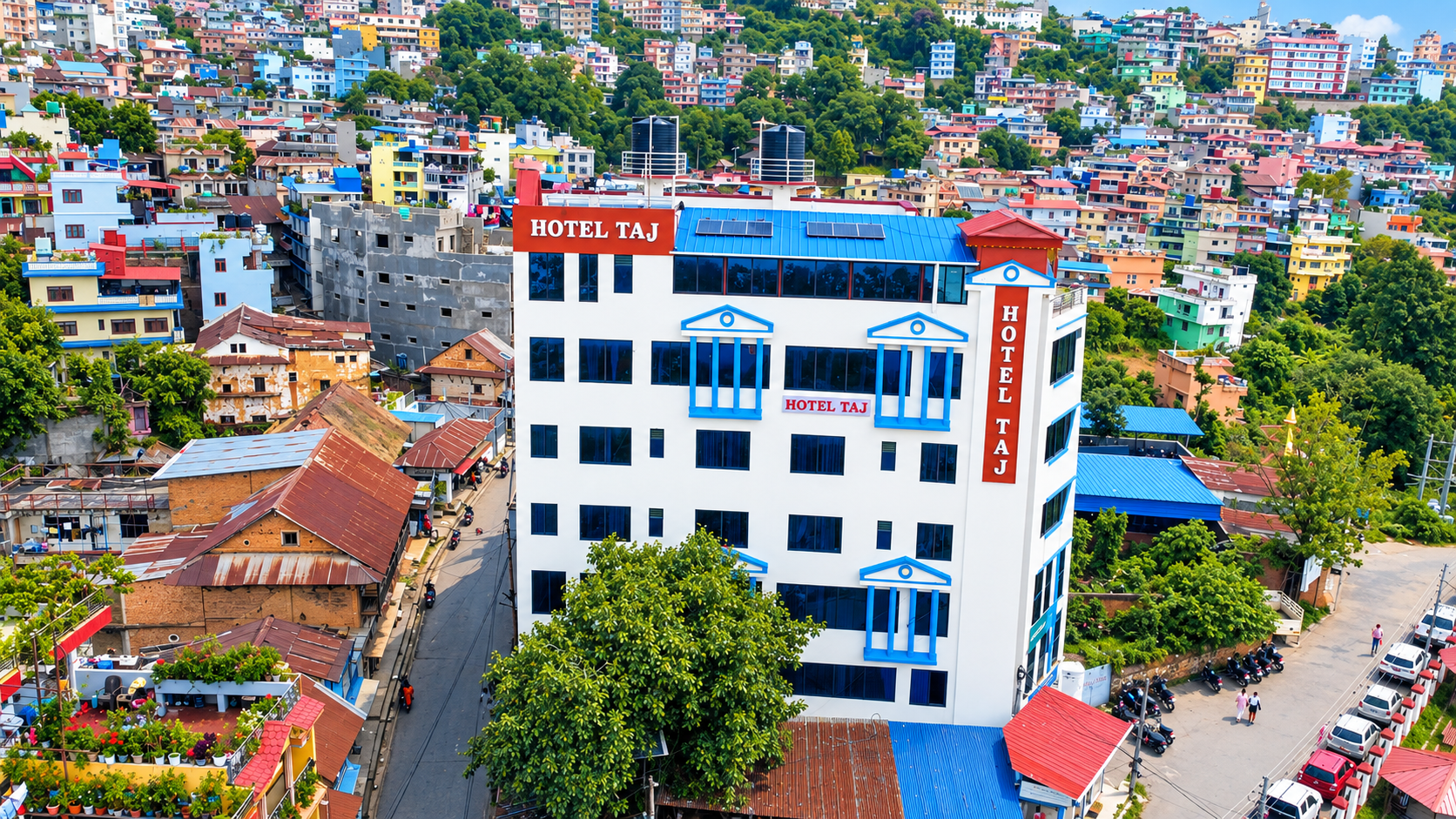 Hotel Taj building with its blue roof and red hotel signs among the hills of Tansen