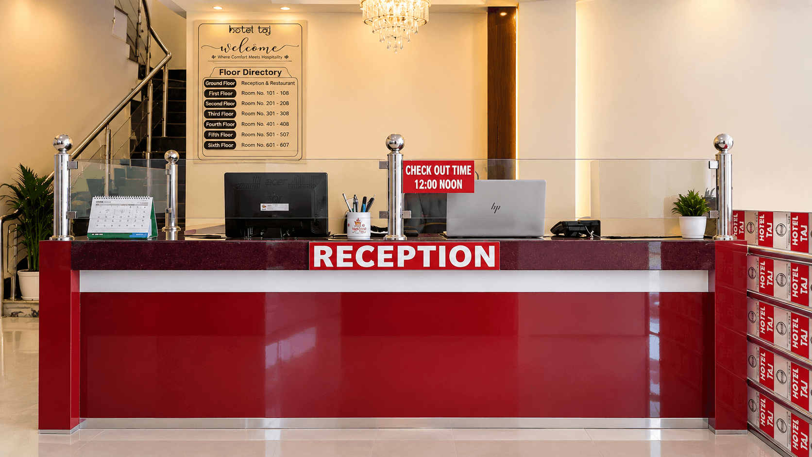 Hotel Taj front desk with a red reception counter, chandelier, and floor directory